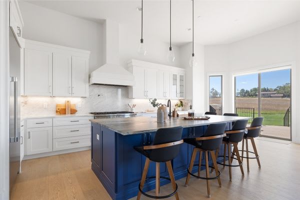 modern kitchen with blue island and bar stools.